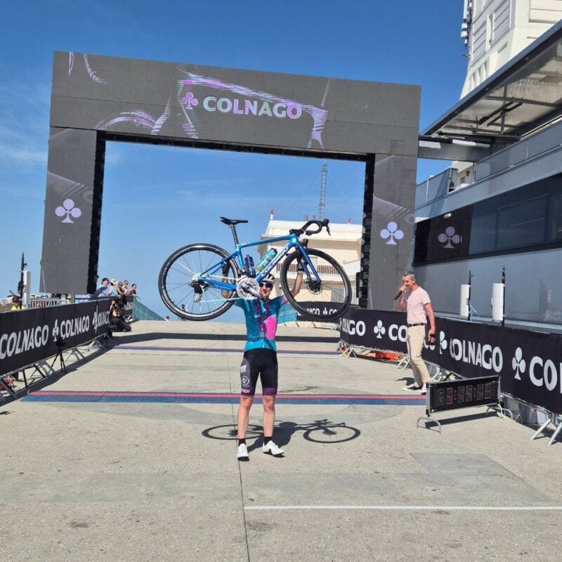 Delphine Reinert soulevant son vélo après son arrivée au sommet du Ventoux